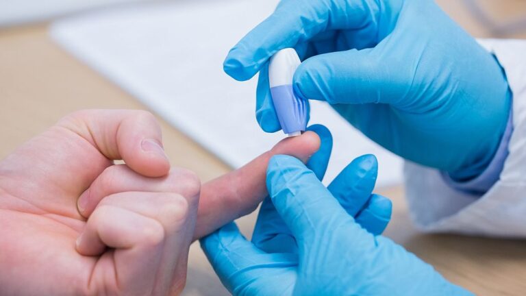 An index finger being pricked to draw blood for testing.