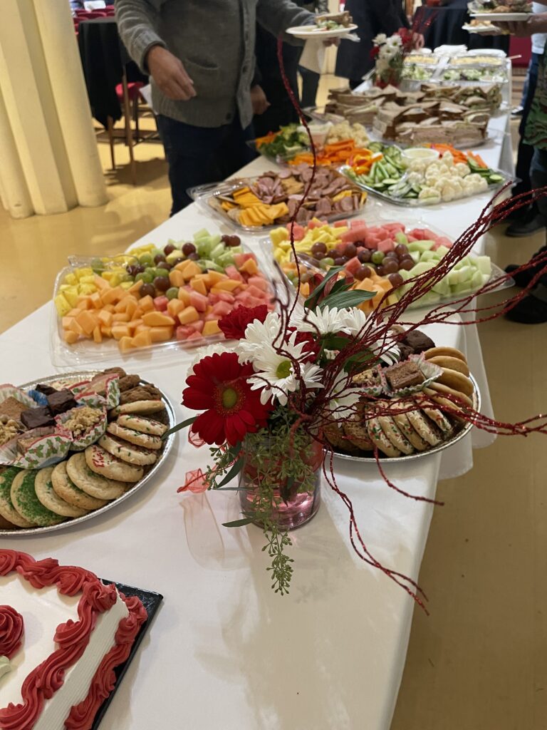 A long table covered in plates of food and flowers.