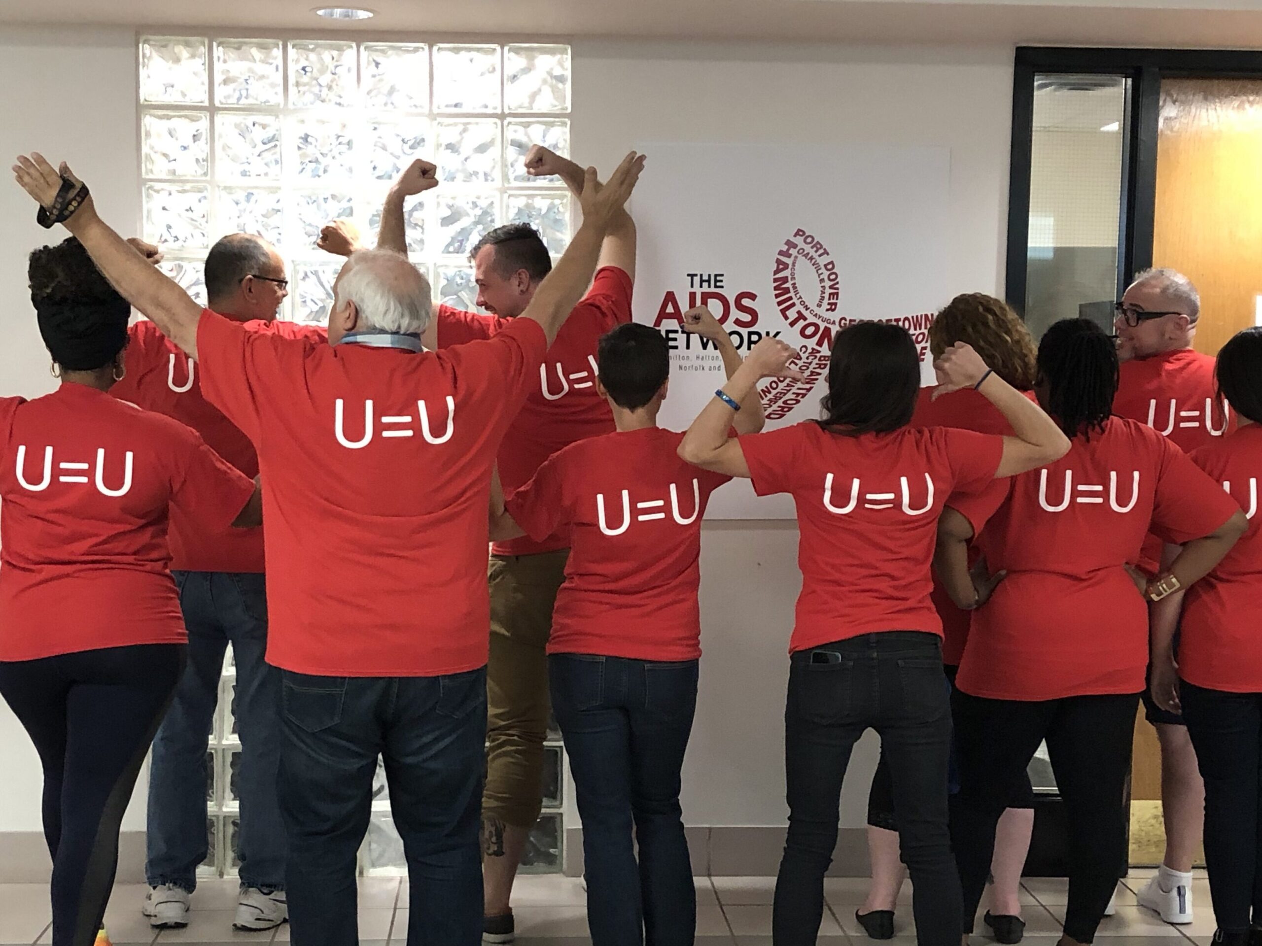 The Positive Health Network's staff showing off their 'U=U' shirts.