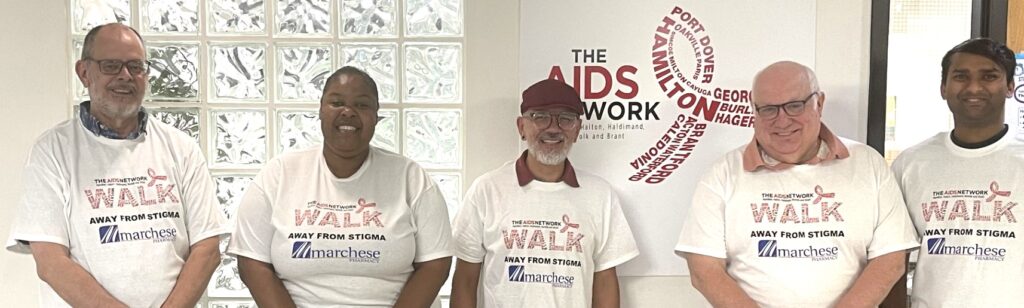 Picture of staff with white Walk T-Shirts from last year 2023.  T-Shirts have the Walk logo with words that say Walk Away from Stigma and Marchese Pharmacy logo on it as they were the title sponsor of the Walk in 2023.